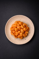 Delicious fresh pasta with pesto sauce, salt, spices and herbs on a ceramic plate