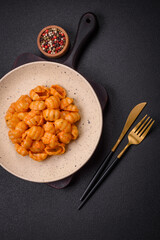 Delicious fresh pasta with pesto sauce, salt, spices and herbs on a ceramic plate