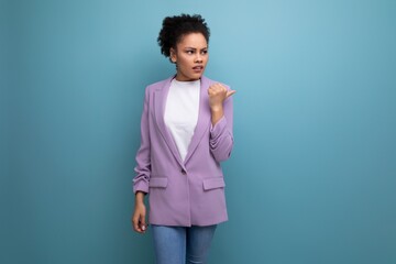 young latin business woman with ponytail hairstyle dressed in purple jacket on studio background...