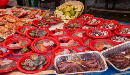 Mediterranean seafood street trade in Sicily. Dishes with fish, mussels, shrimps and octopus