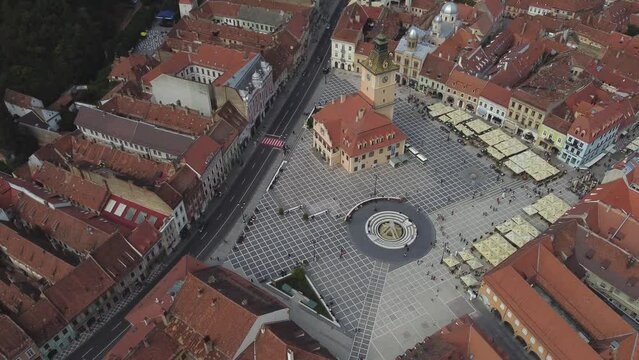 Orbiting aerial shot over Piata Sfatului in old city center of Brasov, Romania