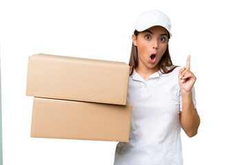 Delivery caucasian woman holding boxes isolated on green chroma background intending to realizes the solution while lifting a finger up