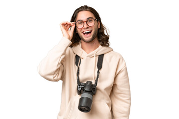 Young photographer man over isolated background with glasses and surprised