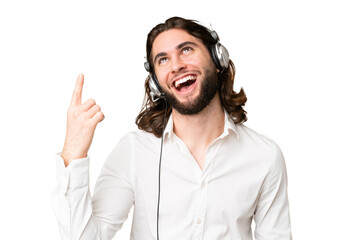 Telemarketer man working with a headset over isolated chroma key background pointing up and surprised