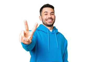 Fototapeta premium Young handsome caucasian man over isolated chroma key background smiling and showing victory sign