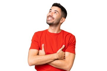 Young handsome caucasian man over isolated chroma key background looking up while smiling