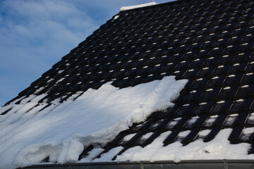 rain gutters but without snow guards in winter with many snow on the rooftop dangerous situation