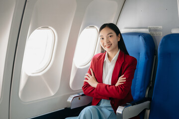 Young Asian executive excels in first class, multitasking with digital tablet, laptop and...