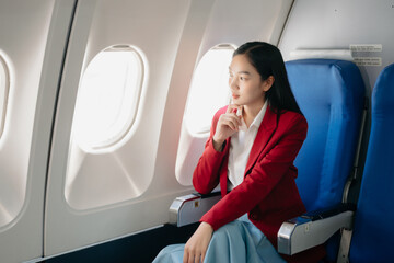 Photo of a frustrated woman sitting on an airplane with her head in her hands. woman sitting in a...