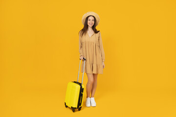 Young girl with a suitcase on a yellow background.