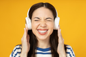 A girl in headphones on a yellow background.