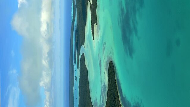 Aerial panning shot above Saint Maurice bay in isle of Pines, clouds shadows moving. vertical format