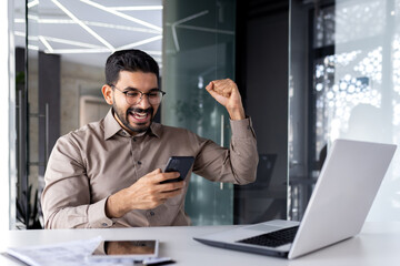 Successful businessman winner inside office at workplace, man received online notification of...
