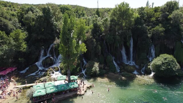 Summer day at Kravica Waterfall with tourists, Bosnia. Aerial