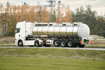 Dangerous goods transportation by semi truck with propane tank. The tank truck has a side view and...