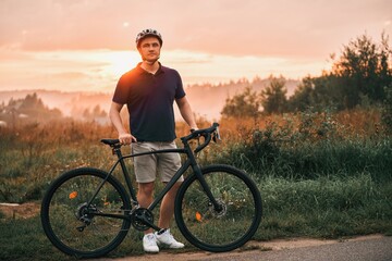 A silhouette of a cyclist training on a trail with a gravel bike, enjoying the adventure and the sport concept in the sunset. - obrazy, fototapety, plakaty