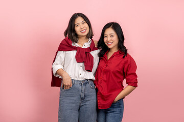 Asian girl in stylish clothes poses on a pink background. Attractive woman in red shirt and jeans....