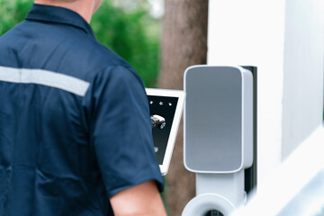Qualified technician install home EV charging station, providing maintenance service for electric...