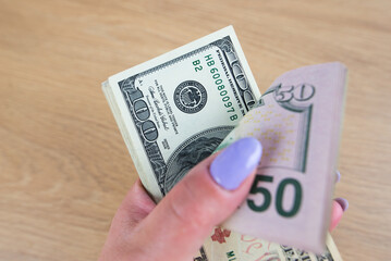 Dollars in a woman's hand close-up. Much money.