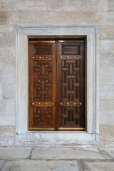 Wooden window shutters in a mosque with Arabic ornaments.