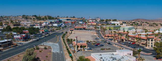Aerial view of a Barstow U.S. town nestled in a desert valley, featuring beige and brown buildings...