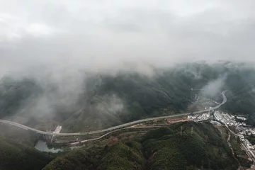 Photo sur Plexiglas Monts Huang Aerial shot of Mount Huangshan forest winding mountain road in Anhui