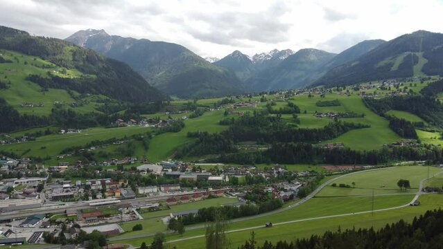 4K drone shot of beautiful  Schladming, Styria, Austria. Lush green fields and houses at the foot of Dachstein Glacier, popular area for Alpine skiing and snowboarding.