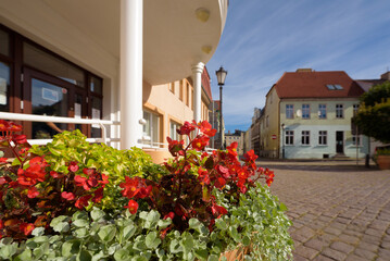 
SUNNY DAY IN THE CITY - A flower bed in the center of small town with local government office and...