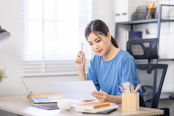 Portrait of young Business asian woman using computer at home sitting in the office working and...