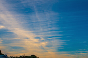 A strip of airplane tracks in the evening blue sky, the impact of aviation on atmospheric phenomena