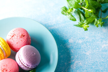 Colored macaroons. Delicious sweet colorful French desserts on light background. Desserts on a blue...
