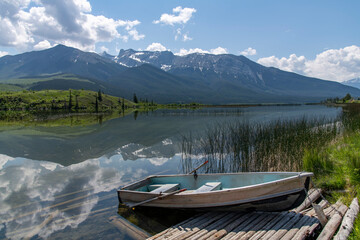 Low angle view steel rowboat on Talbot Lake, Alberta, Canada with Emir Mountain in background and...