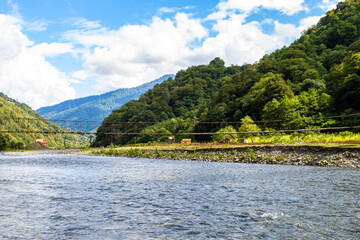 Fototapeta premium travel to Georgia - Machakhelistsqali river with suspension bridge in mountain in Adjara on sunny autumn day