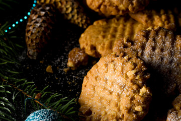 Peanut round cookies. Festive cookies for the new year, against the background of a Christmas tree and garlands. Low key