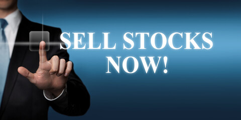 sell stocks now - businessman pressing virtual touchscreen button