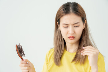 Asian woman very sad and upset looking at damaged hair, hair loss, hair thinning problem, vitamin...