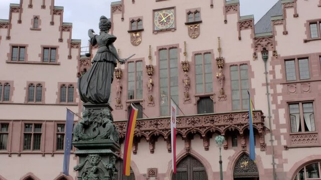 Static mid clip of statue of justice in Romerberg Frankfurt with ornate buildings behind