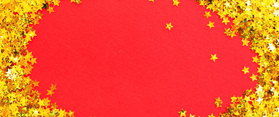 christmas shiny red background with festive golden confetti like a frame with copy space for text.