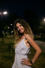 Portrait of beautiful smiling woman in summer dress at night