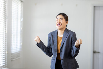 Happy excited Young asian businesswoman in the office working with a laptop computer, Yes great job.
