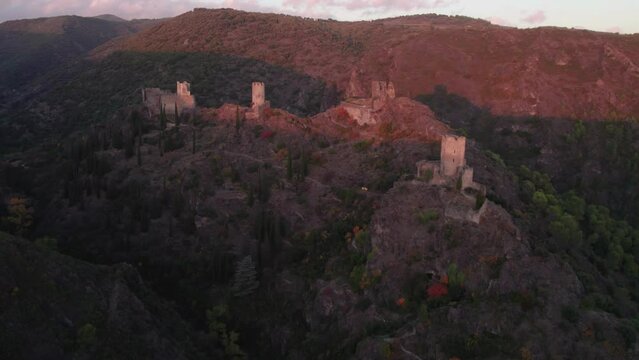 Aerial view of the Lastours castle ruins in the French mountains during sunset.