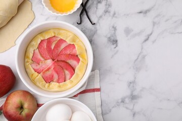 Flat lay composition with fresh dough, apples and other ingredients on white marble table, space for text. Making galette