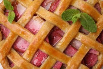 Delicious apple pie with mint as background, top view