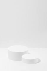 Abstract stage mockup with set of two round podiums in hard light for presentation cosmetic products, goods, advertising, design on white background. Abstract scene in light modern minimal style.