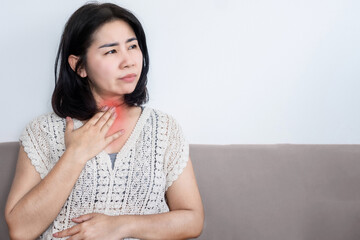 Asian woman suffering from chronic heartburn from acid reflux feeling uncomfortable, sore throat concept