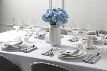 Beautiful table setting with cards and floral decor indoors