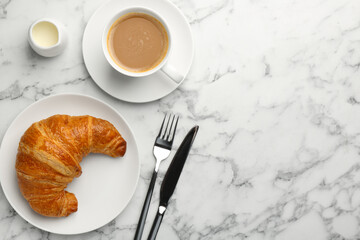 Delicious fresh croissant served with coffee on light marble table, flat lay. Space for text