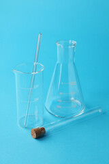 Different laboratory glassware on light blue background