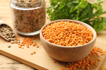 Different types of lentils on wooden table, closeup