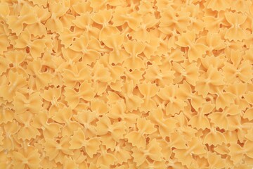 Raw farfalle pasta as background, top view